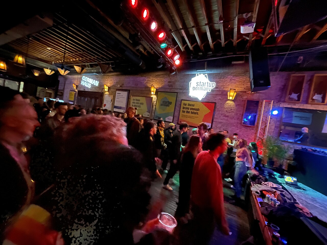 Abendliches-Networking-Event-German-Haus-SXSW.jpg Belebte Networking- und Party-Szene im German Haus auf der SXSW in Austin, Texas, mit Tanzfläche, DJ und dynamischer Atmosphäre.